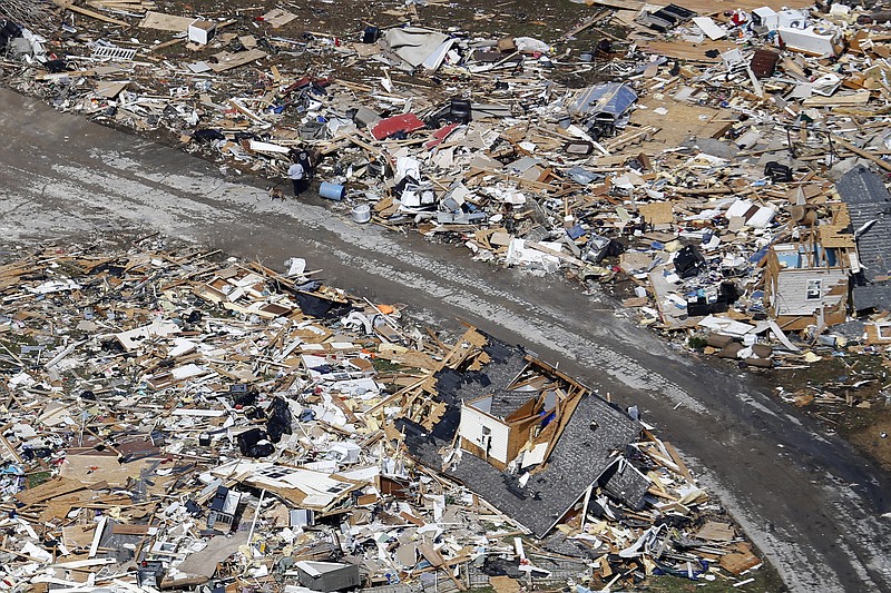 A road separates properties filled with debris Tuesday, March 3, 2020, near Lebanon, Tenn. Tornadoes ripped across Tennessee early Tuesday, shredding more than 140 buildings and burying people in piles of rubble and wrecked basements.  (AP Photo/Mark Humphrey)