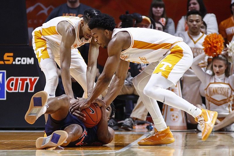 AP photo by Wade Payne / Auburn's Allen Flanigan tries to hold on to the ball on the court as Tennessee guards Josiah-Jordan James, right, and Jalen Johnson fight for possession during Saturday's game in Knoxville.