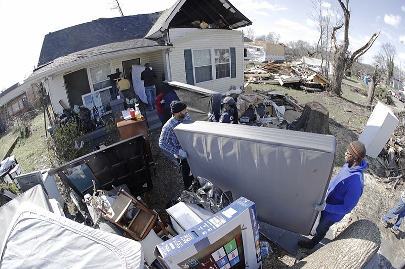 A group of volunteers moves items salvaged from a damaged home Friday, March 6, 2020, in Nashville, Tenn. Residents and businesses face a huge cleanup effort after tornadoes hit the state Tuesday. (AP Photo/Mark Humphrey)

