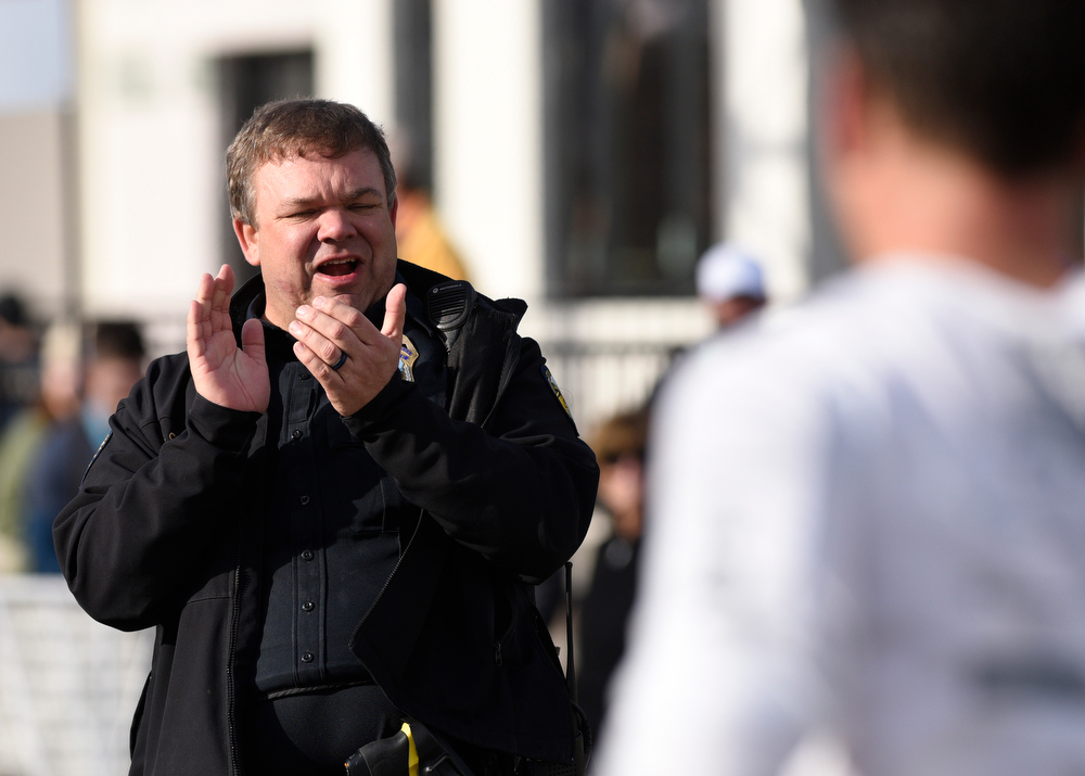 Staff Photo by Robin Rudd / Chattanooga Police officer John Collins encourages runners just before the finish line. The 5th Erlanger Chattanooga Marathon was run on March 8, 2020.