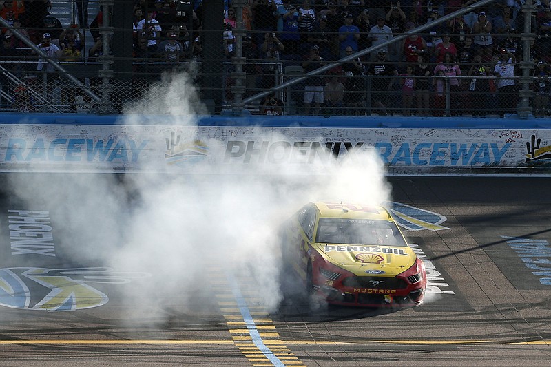 AP photo by Ralph Freso / NASCAR driver Joey Logano does a burnout across the start/finish line at Phoenix Raceway after winning Sunday's Cup Series race in Avondale, Ariz.