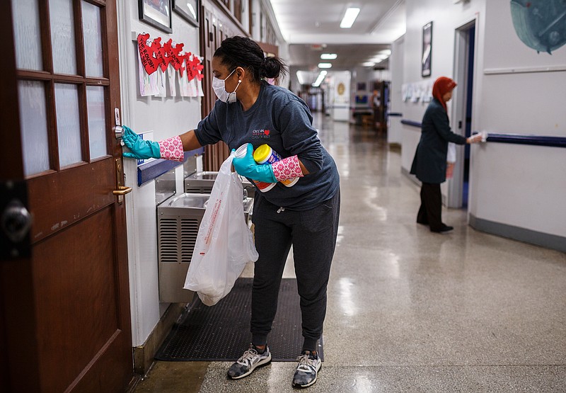 File staff photo by Doug Strickland / Parent volunteer Nichole Newson wipes down a door during a group effort to sanitize surfaces at Chattanooga School for the Arts and Sciences on Tuesday, Jan. 30, 2018, in Chattanooga, Tenn. As the country grapples with one of the worst flu seasons in years, schools are working to combat the spread of the disease. Now, Hamilton County Schools is preparing for the potential impact of the novel coronavirus as the number of cases across the United States increase.