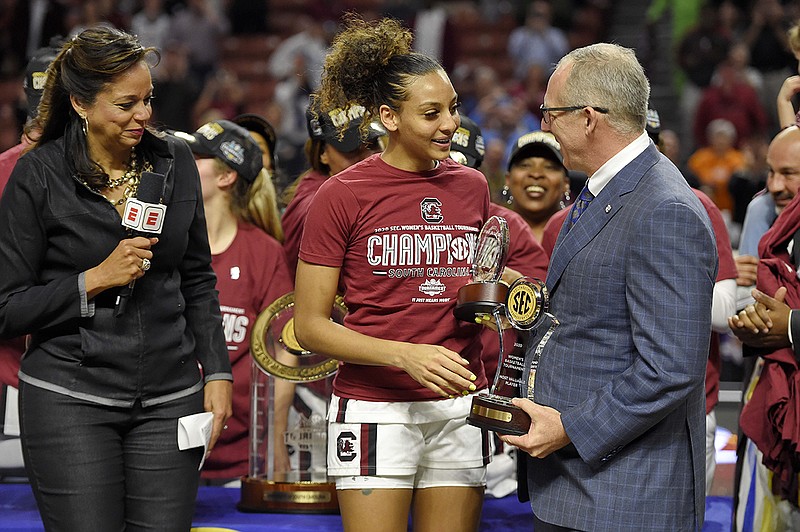 AP photo by Richard Shiro / South Carolina basketball player Mikiah Herbert-Harrigan, center, is presented with the tournament MVP trophy by SEC commissioner Greg Sankey, right, as ESPN's Carolyn Peck watches after the Gamecocks beat Mississippi State 76-62 in the title game Sunday in Greenville, S.C.