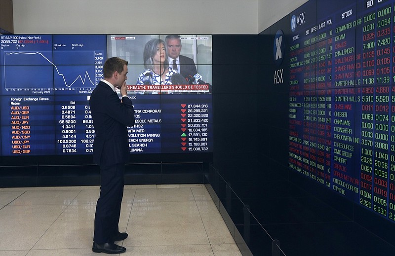 A man stands in the viewing gallery at the Australian Stock Exchange in Sydney, Monday, March 9, 2020. Asian stock market plunge after fall in oil prices. Asian stock markets plunged Monday after oil prices nosedived on worries a global economy weakened by a virus outbreak might be awash in too much crude. (AP Photo/Rick Rycroft)