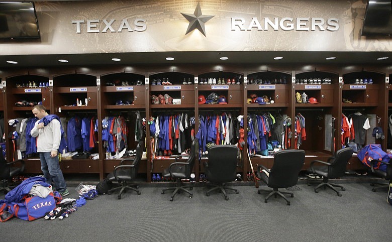 In this Oct. 11, 2016, file photo, Texas Rangers pitcher Sam Dyson, left, packs a bag in the locker room at the baseball park in Arlington, Texas. The NBA, NHL, Major League Baseball and Major League Soccer are closing access to locker rooms and clubhouses to all non-essential personnel in response to the coronavirus crisis, the leagues announced in a joint statement Monday, March 9, 2020. (AP Photo/LM Otero, File)