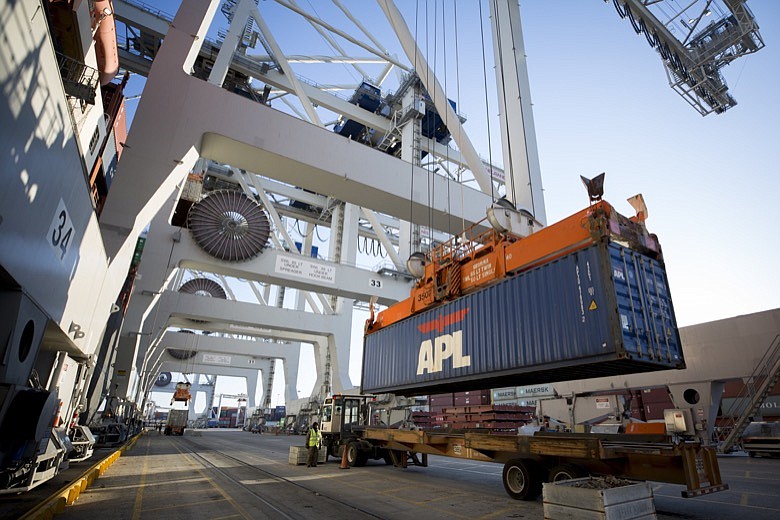 In this Jan. 30, 2018, file photo, an APL shipping container is lifted on to a vessel by a ship to shore crane at the Georgia Ports Authority's Port of Savannah in Savannah, Ga. Georgia's seaports are reporting record cargo volumes that moved across their docks in the 2019 calendar year. (AP Photo/Stephen B. Morton, File)