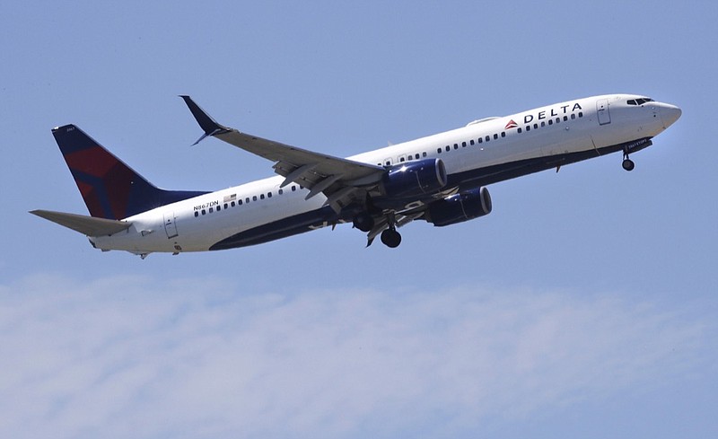 FILE- In this May 24, 2018, file photo a Delta Air Lines passenger jet plane, a Boeing 737-900 model, approaches Logan Airport in Boston. Airlines are seeing a sharp drop in bookings and a rise in cancellations in recent days as the coronavirus outbreak continues to spread, and they are responding by slashing flights and freezing hiring. Normally airlines try to lure reluctant customers by discounting fares, but that won't work in the face of the COVID-19 outbreak. (AP Photo/Charles Krupa, File)