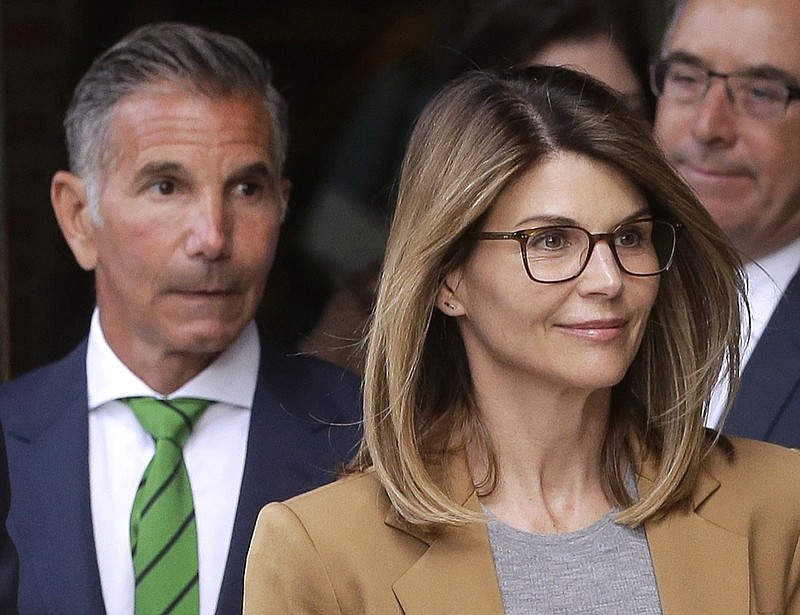FILE - In this April 3, 2019, file photo, actress Lori Loughlin, front, and her husband, clothing designer Mossimo Giannulli, left, depart federal court in Boston. Eight parents, including Loughlin and Giannulli, are scheduled to go on trial in October 2020 for their involvement in a college admissions cheating scheme. (AP Photo/Steven Senne, File)