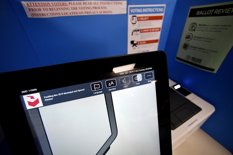 In this Tuesday, Nov. 5, 2019 photo, a touchscreen voting machine and printer are seen in a voting booth, in Paulding, Ga. Georgia's state election board has scheduled an emergency hearing Wednesday, March 11, 2020, to determine whether a county election board violated state laws and election rules when it voted to use hand-marked paper ballots instead of the state's new voting machines for the presidential primary. (AP Photo/Mike Stewart)


