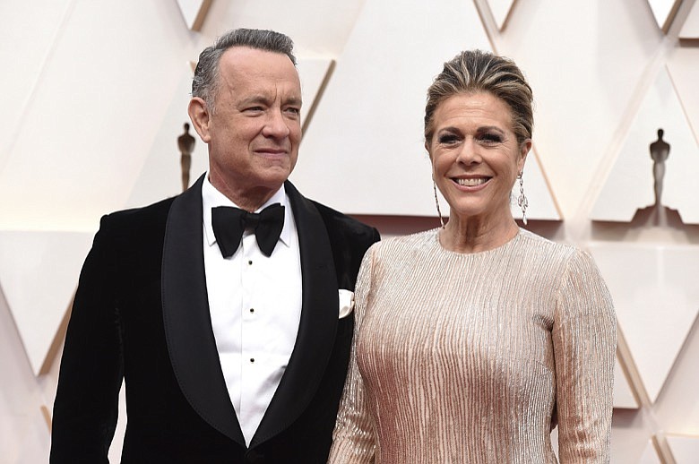 In this Feb. 9, 2020, file photo, Tom Hanks, left, and Rita Wilson arrive at the Oscars at the Dolby Theatre in Los Angeles. The couple have tested positive for the coronavirus, the actor said in a statement Wednesday, March 11. The 63-year-old actor said they will be "tested, observed and isolated for as long as public health and safety requires." (Photo by Jordan Strauss/Invision/AP, File)