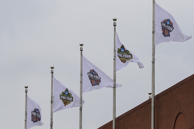 AP photo by Michael Conroy / Flags for the 2020 Division I men's basketball tournament's Final Four fly over the national office of the NCAA on Thursday in Indianapolis. The NCAA canceled the Division I men's and women's basketball tournaments, as well as the rest of its winter and spring sports championships, amid coronavirus concerns.