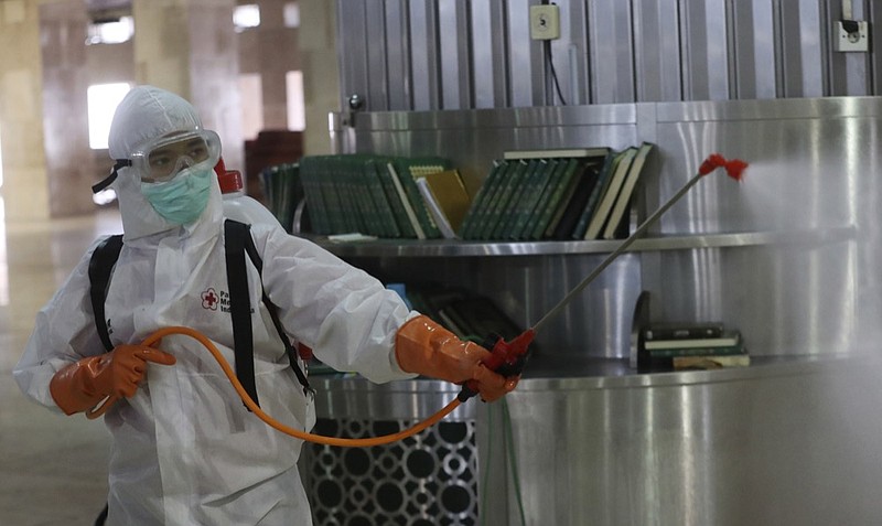 An official sprays disinfectant in the wake of the new coronavirus outbreak at Istiglal mosque in Jakarta, Indonesia, Friday, March 13, 2020. For most people the new coronavirus causes only mild or moderate symptoms, such as fever and cough. For some, especially older adults and people with existing health problems, it can cause more severe illness including pneumonia. (AP Photo/Achmad Ibrahim)


