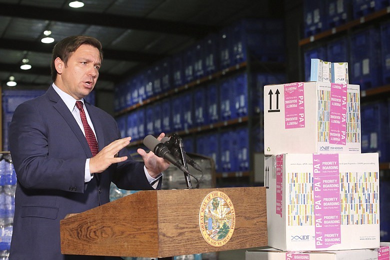 Florida Gov. Ron DeSantis speaks at a news conference at an emergency management warehouse alongside props of testing kits about the spread of the coronavirus, Friday March 13, 2020 in Tallahassee, Fla. The vast majority of people recover from the new coronavirus. According to the World Health Organization, most people recover in about two to six weeks, depending on the severity of the illness. (AP Photo/Steve Cannon)