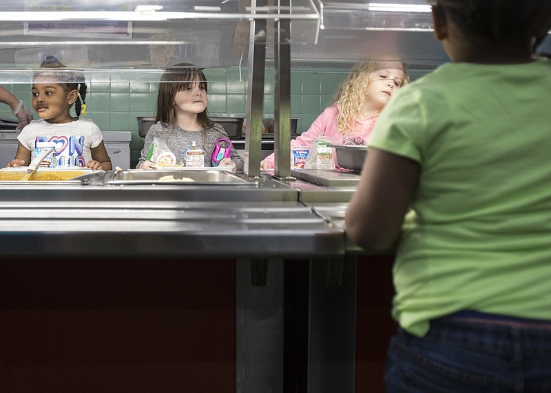 Staff photo by Troy Stolt / Pre K students Nivayeh O'neal, 4, left, and Harper Lietchy, 5, go through the lunch line at Rivermont elementary school on Friday, March 13, 2020 in Chattanooga, Tenn. 
