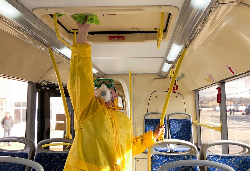 In this photo taken on Thursday, March 12, 2020, A bus depot employee disinfects a bus in Moscow, Russia. For most people, the new COVID-19 coronavirus causes only mild or moderate symptoms, such as fever and cough. For some, especially older adults and people with existing health problems, it can cause more severe illness, including pneumonia. (Denis Voronin, Moscow News Agency photo via AP)