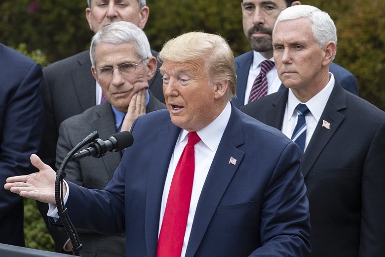 President Donald Trump, accompanied by Dr. Anthony Fauci, director of the National Institute of Allergy and Infectious Diseases, left, and Vice President Mike Pence, right, speaks during a news conference about the coronavirus in the Rose Garden at the White House, Friday, March 13, 2020, in Washington. (AP Photo/Alex Brandon)