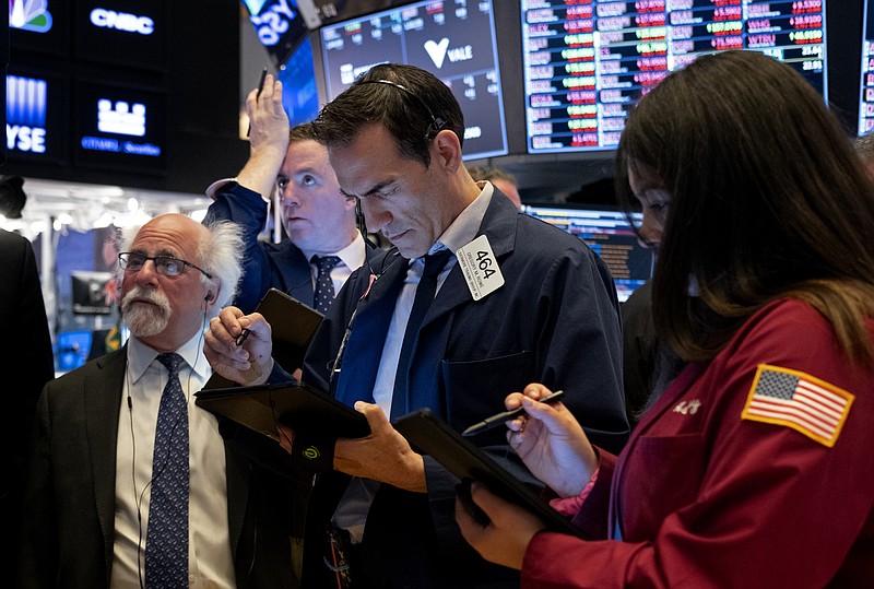 Trader Gregory Rowe, center, and others work on the floor of the New York Stock Exchange Monday, March 16, 2020. (AP Photo/Craig Ruttle)