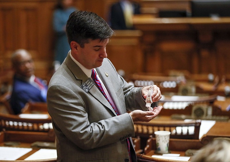 Sen. Matt Brass, R - Newnan, applies hand sanitizer before a special session on Monday, March 16, 2020 in Atlanta. Georgia's lawmakers are granting Gov. Brian Kemp broad powers to combat the spread of the new coronavirus in the state. They set April 13, the Monday after Easter, as the end date for Kemp's powers. The vast majority of people recover from the new coronavirus. According to the World Health Organization, most people recover in about two to six weeks, depending on the severity of the illness. (Bob Andres/Atlanta Journal-Constitution via AP)