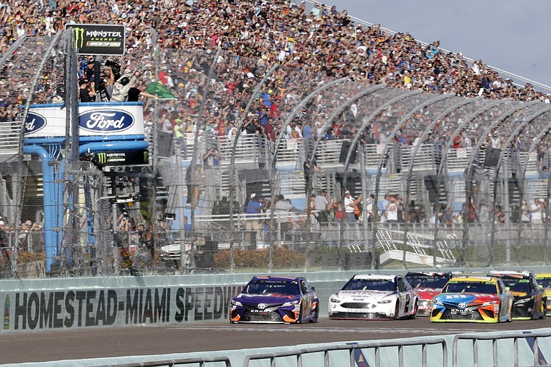 FILE - In this Nov. 18, 2018, file photo, Denny Hamlin, left, leads the pack at the start of the NASCAR Cup Series championship auto race at Homestead-Miami Speedway, in Homestead, Fla. NASCAR and IndyCar have each called off their races this weekend. NASCAR was scheduled to run Sunday at Atlanta Motor Speedway without spectators but said Friday, March 13, 2020, it is calling off this weekend and next week's race at Homestead-Miami Speedway. IndyCar was scheduled to open its season Sunday on the streets of St. Petersburg, Florida, but suspended it's season through the end of April. (AP Photo/Lynne Sladky, File)


