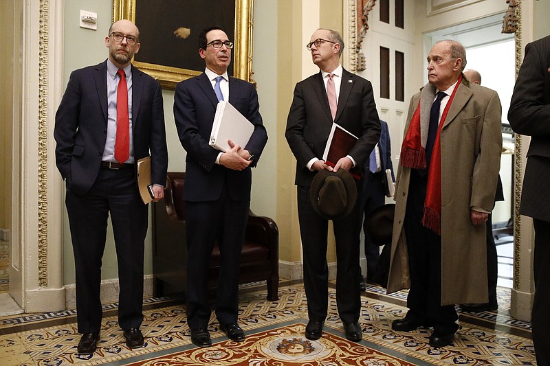 Treasury Secretary Steve Mnuchin, second from left, speaks with members of the media as he departs a meeting with Senate Republicans on an economic lifeline for Americans affected by the coronavirus outbreak. on Capitol Hill in Washington, Monday, March 16, 2020. Standing with Mnuchin is White House chief economic adviser Larry Kudlow, right. (AP Photo/Patrick Semansky)


