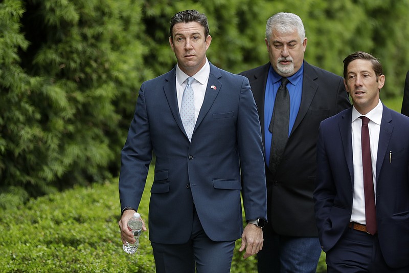 Convicted ex-Rep. Duncan Hunter, left, walks towards a court building for sentencing Tuesday, March 17, 2020, in San Diego. Hunter faces up to five years in prison after pleading guilty on a corruption charge. Hunter served six terms representing one of Southern California's last solidly Republican districts before he resigned. (AP Photo/Gregory Bull)


