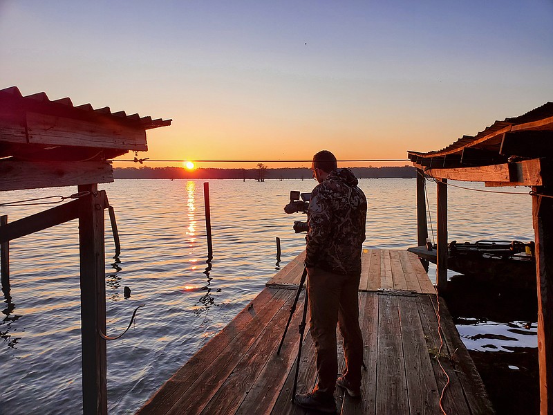 Photo by Larry Case / Logan Bockrath shoots footage of a sunrise in late February at Reelfoot Lake in Tennessee near Kentucky and Missouri.