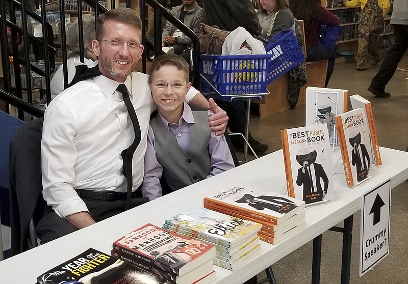 Author Matt Deaton poses with his son, 11-year-old Justin, at a book signing. / Contributed photo by Lisa Fairbanks