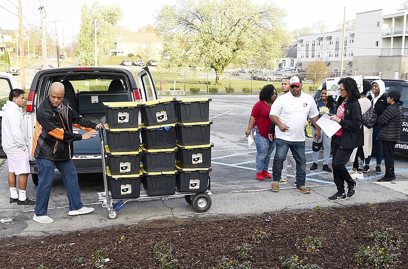 Staff Photo by Robin Rudd / Chattanooga Girls Leadership Academy staff and volunteers move the supplies to the buses. CGLA established Mustang Express to ease some of the burden caused by the COVID-19 crisis by suppling students and their families with meals and household supplies. The first run of the express left CGLA early in the morning on March 19, 2020.