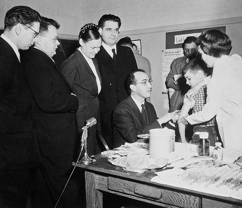 Four Russian scientists watch Dr. Jonas Salk, discoverer of the anti-polio vaccine bearing his name, inoculate a youngster in Pittsburgh in 1956, Jan 30, 1956.