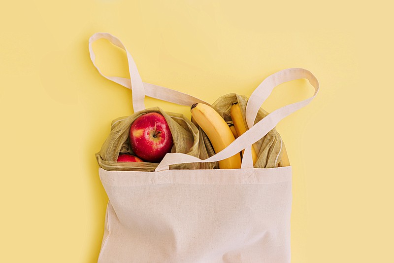 Natural eco bag with fruits on yellow background. Zero waste shopping and plastic free concept. Eco friendly, flat lay. grocery tile groceries shopping / Getty Images
