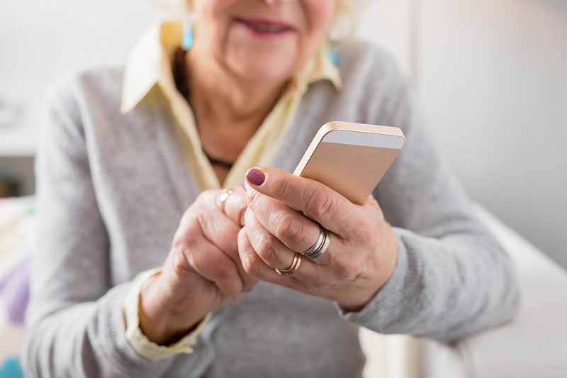 Senior using a phone / Getty Images
