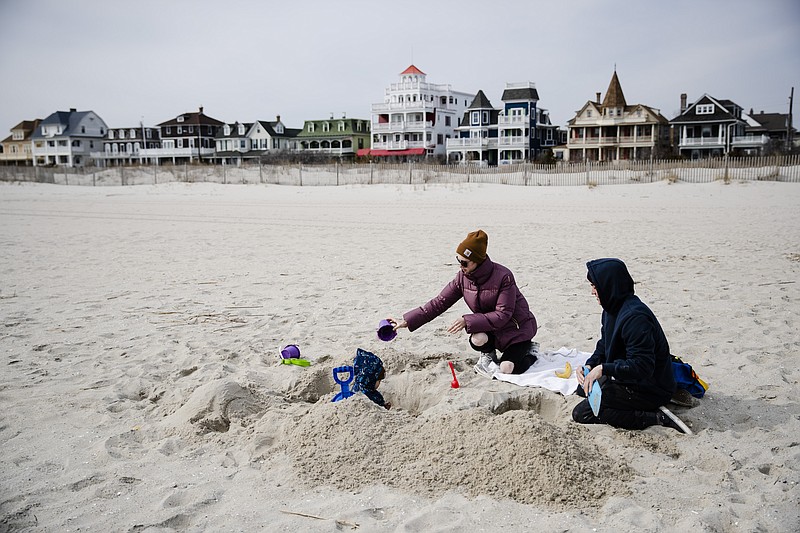 Matt and Anna Mason play with their son, Oliver, on the beach in Cape May, N.J., Wednesday, March 18, 2020. The Masons live and work in Cape May. (AP Photo/Matt Rourke)


