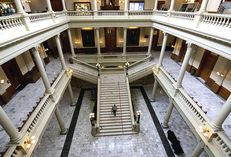 Travis Swann Taylor walks through a nearly empty Georgia State Capitol on Thursday, March 19, 2020, after Georgia lawmakers were urged Wednesday to self-isolate themselves, after a state senator said he tested positive for the coronavirus. (Steve SchaeferAtlanta Journal-Constitution via AP)


