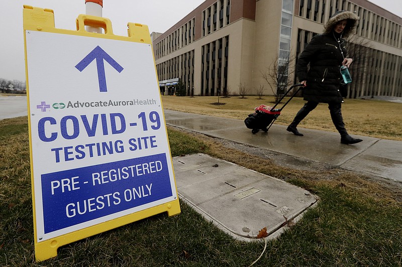 FILE - In this Wednesday, March 18, 2020 file photo, a pedestrian walks past a COVID-19 testing sign at Advocate Lutheran General Hospital in Park Ridge, Ill. Some bored with the limitations of the term "COVID-19" and the even clunkier name of the virus that causes it — severe acute respiratory syndrome coronavirus 2 — have come up with their own shorthand. On Thursday, Eric Acton, a linguist at Eastern Michigan University, said, "One of my students just referred to the virus as "The Ronies," after a research group meeting conducted virtually. (AP Photo/Nam Y. Huh)


