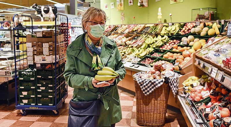 A woman buys fruits at a supermarket in Bergisch Gladbach that is open in the morning only for elderly people from 65 years to minimize their risk of infection due to the coronavirus outbreak in Germany, Friday, March 20, 2020. For most people, the new coronavirus causes only mild or moderate symptoms, such as fever and cough. For some, especially older adults and people with existing health problems, it can cause more severe illness, including pneumonia. (AP Photo/Martin Meissner)


