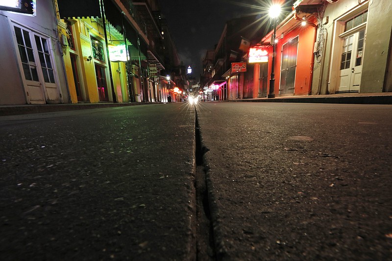 FILE - In this Thursday, March 19, 2020, file photo, a view of the nearly deserted scene on Bourbon Street, which is normally bustling with tourists and revelers, in the French Quarter of New Orleans. In the city here, the old saying "Let the good times roll" has given way to a new municipal maxim: "Wash your hands." Due to the coronavirus outbreak, New Orleans has joined those places shutting down bars, eliminating restaurant dining and banning crowds. (AP Photo/Gerald Herbert, File)


