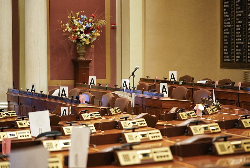 FILE - In this Wednesday, March 18, 2020 file photo, the House chamber at the state Capitol is empty in St. Paul, Minn., with some desks marked with an "A" - those desks may be occupied when lawmakers return to maintain "social distancing" because of the COVID-19 coronavirus. (Glen Stubbe/Star Tribune via AP)


