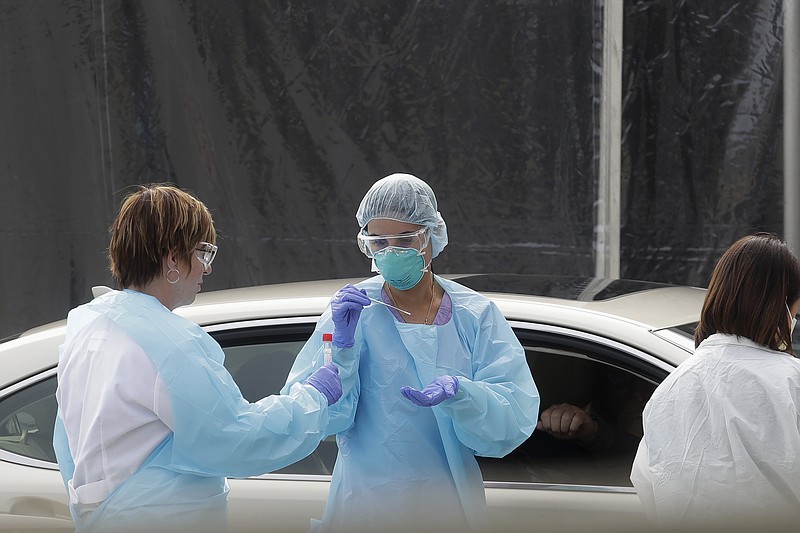 FILE - In this March 12, 2020, file photo, health care personnel test a person in the passenger seat of a car for coronavirus at a Kaiser Permanente medical center parking lot in San Francisco. The Associated Press has found that the critical shortage of testing swabs, protective masks, surgical gowns and hand sanitizer can be tied to a sudden drop in imports of medical supplies. (AP Photo/Jeff Chiu, File)


