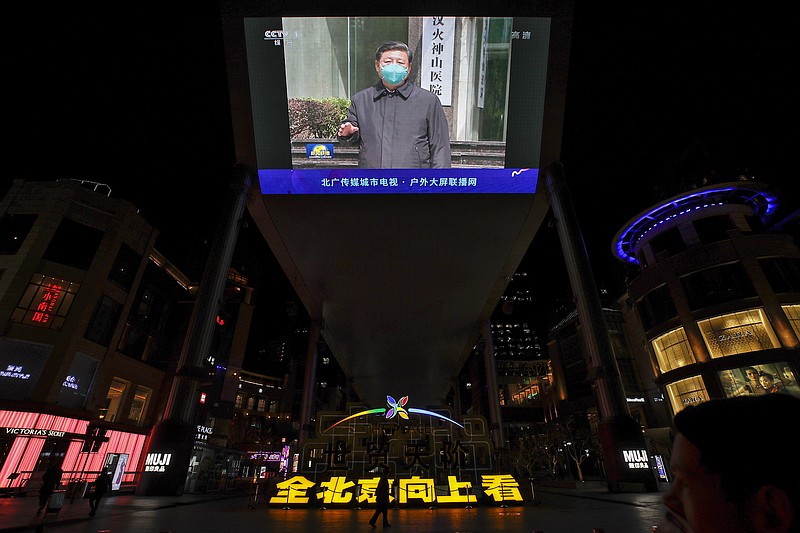 Phot by Andy Wong of The Associated Press / People walk by a giant TV screen broadcasting a news of Chinese President Xi Jinping talks to medical workers as he visiting the Huoshenshan Hospital in Wuhan in central China's Hubei Province, at a quiet shopping mall in Beijing on Tuesday, March 10, 2020.