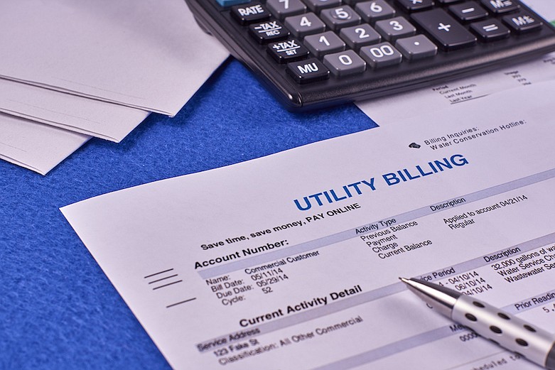 Utility billing sheet, calculator, pen and envelopes, bills. / Getty Images/
iStock/Maksim Shchur