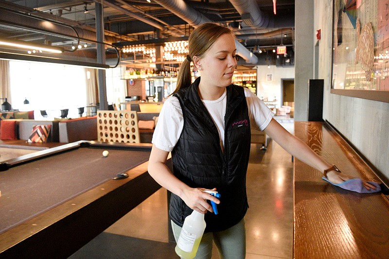 Staff Photo by Robin Rudd / Kelly Helton, assistant general manager at the Moxy, cleans surfaces during downtime at the hotel. The hotel industry has lost guests and jobs amid the coronavirus crisis.