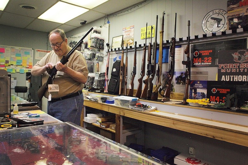 Staff photo by Wyatt Massey / David Smith, owner of Dave's Shooting Supply in Red Bank, cleans a rifle in his store on March 24. Shooting supply stores across the country have seen a spike in sales from concerns over COVID-19.