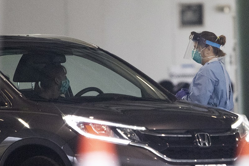 A person is given a test for COVID-19 coronavirus at a drive through testing location Wednesday, March 18, 2020, in Marietta, Ga. The testing is not open to the public people must be referred by the health department. (AP Photo/John Bazemore)


