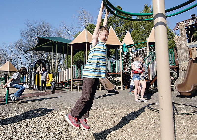 Cody Blair, 8, spins around on a piece of playground equipment at Imagination Station in Collegedale. / Staff File Photo