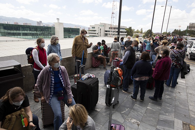 Travelers wait to take a charter flight coordinated by the U.S. embassy at La Aurora airport in Guatemala City, Monday, March 23, 2020. American citizens stranded abroad because of the coronavirus pandemic are seeking help in returning to the United States. (AP Photo/Moises Castillo)

