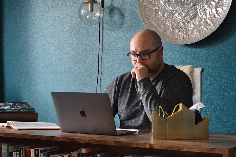 In this photo provided by Brett Seidl, Jonathon Seidl sits in his home office in Dallas on Wednesday, March 18, 2020. He said he wasn't worried about the coronavirus despite his anxiety disorder. But that changed. The 33-year-old digital media strategist, who takes medication, said his concern was less about getting sick than about the battering the economy could sustain. Would he be able to feed his family? Would there be a run on food stores? He could not shake his worries. (Brett Seidl via AP)

