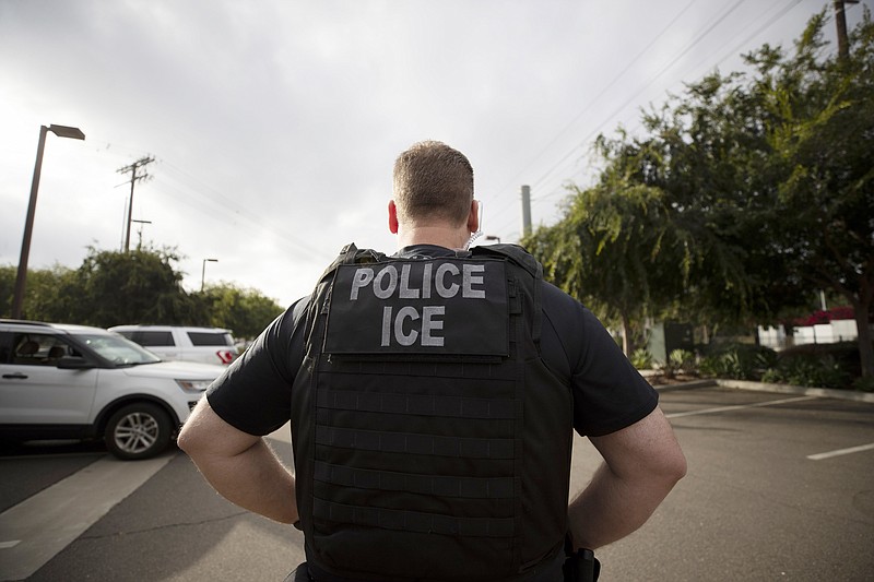 FILE - In this July 8, 2019, file photo, a U.S. Immigration and Customs Enforcement (ICE) officer looks on during an operation in Escondido, Calif. Pressure is mounting on the Trump administration to release people from immigration detention facilities where at least one detainee has already tested positive for COVID-19. (AP Photo/Gregory Bull, File)


