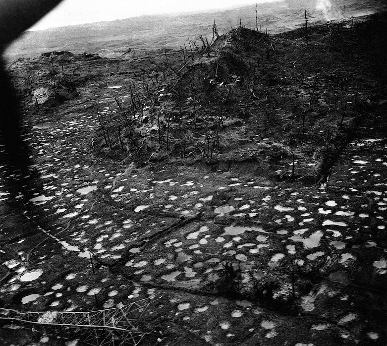 In this image provided by the Tactical Air Force, 10th Army, the polka dot pattern of rain-filled shell holes and the splintered stumps of leafless trees on an Okinawa battlefield attest to the deluge of Tenth Army artillery poured on strong Japanese positions around Shuri Castle in 1945. The demolished Japanese radio tower in the left foreground was one of 11 such installations around this nerve center of the defensive system manned by 80,000 fanatical troops. Caves in small hill at upper left in which Japanese hid to escape bombings and pup tents of American doughboys around hill the center. (AP Photo/Tactical Air Force, 10th Army)