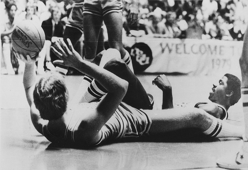 Indiana State's Larry Bird, left, lies on his back to toss the ball during a scramble with Earvin "Magic" Johnson, right, during NCAA Championship game in Salt Lake City, Utah, March 26, 1979. (AP Photo)

