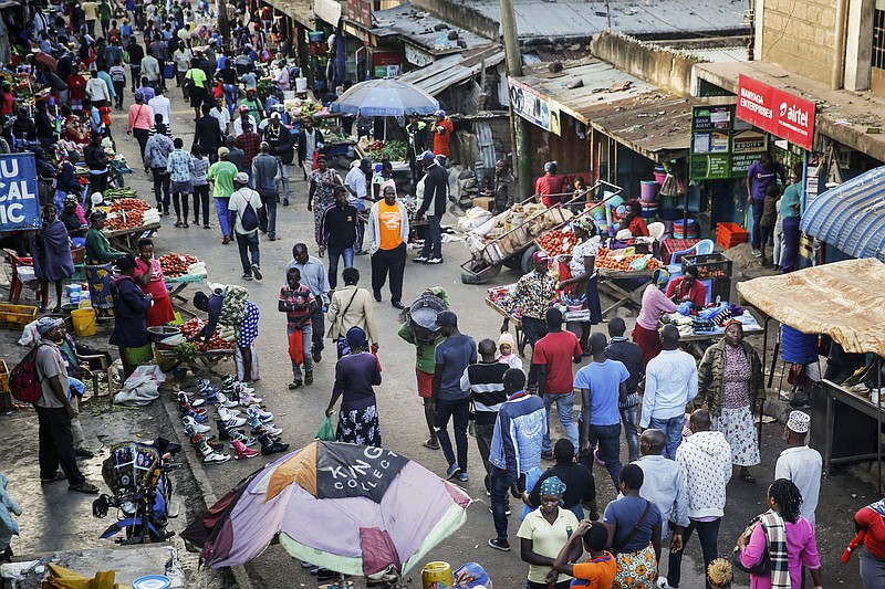 FILE - In this March 24, 2020, file photo, residents walk through a small and crowded market where social-distancing is difficult, in the Mathare slum, or informal settlement, of Nairobi, Kenya. The new coronavirus causes mild or moderate symptoms for most people, but for some, especially older adults and people with existing health problems, it can cause more severe illness or death. (AP Photo/Brian Inganga, File)


